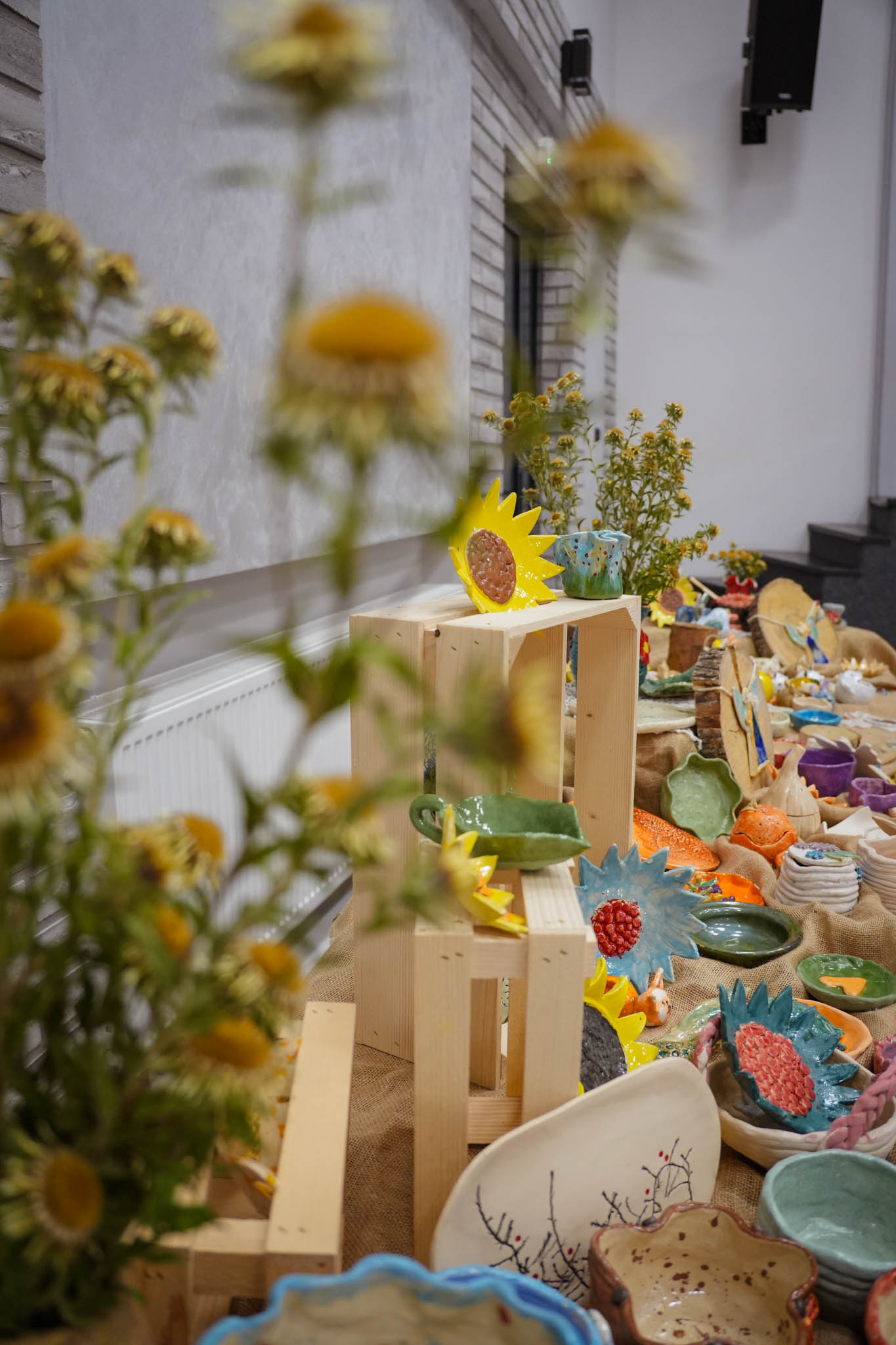 zdjęcie stołu z kwiatami, pełnego prac ceramicznych